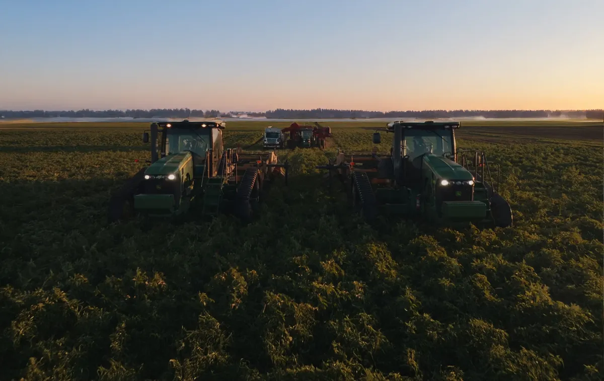 Aerial shot of farm equipment working in a field at the Perry Farm